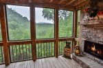 Screened in porch with gas fireplace overlooking mountains.